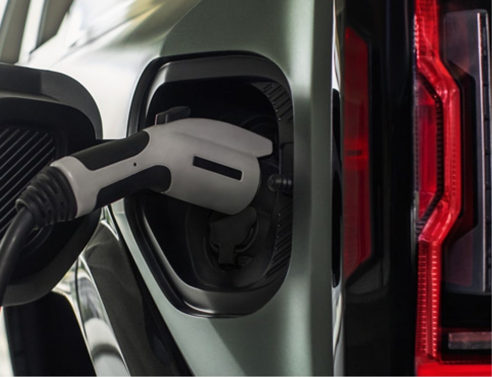 Close up of charging port with charger plugged in on a GMC Hummer EV SUV - Karl GMC Webster City in Webster City IA