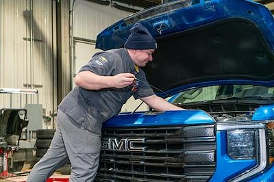Karl GMC of Webster City technician inspecting a tire in the service bay
